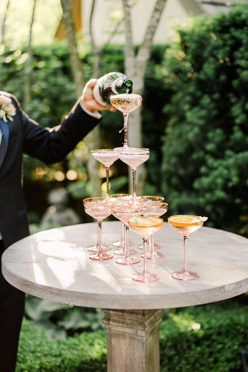 wedding business owner pours champagne into pink glasses