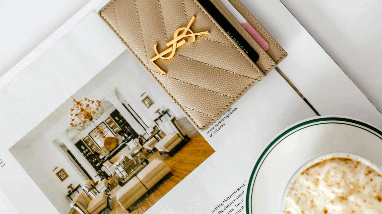 Flatlay of magazine feature with wallet and coffee, symbolizing press coverage and wedding publicity in lifestyle media